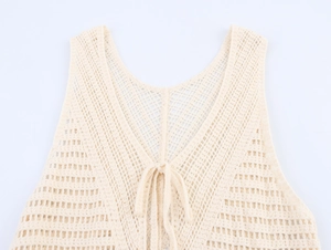 Close-up of beige crochet knit vest showing hollow-out floral pattern and V-neck tie detail