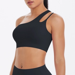 Detail of black one-shoulder sports bra featuring asymmetric cut-out and matte fabric texture