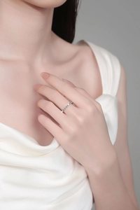 Detail shot of a s925 sterling silver moissanite ring worn by a model in silk attire