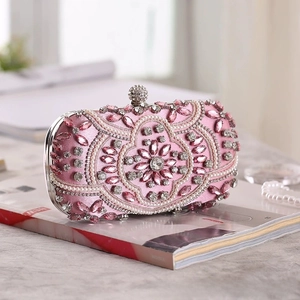 Close-up of pink evening bag with floral beadwork, pearls and rhinestones on satin