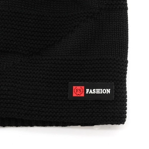 Black knit beanie with fashion leather label and warm ribbed texture for winter outdoor use