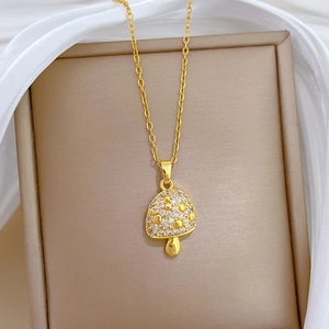 Macro view of gold mushroom pendant with sparkling crystals in a beige jewelry box