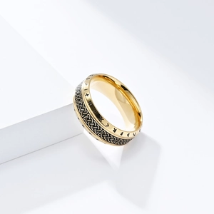 Detail of golden Viking ring with Celtic knots and black etched Nordic runes engraving