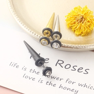 Detailed view of spike cone stud earrings in gold, silver, and black with inset crystals