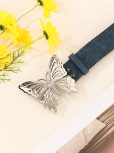 Detail of blue leather belt with vintage silver butterfly buckle and floral embossing