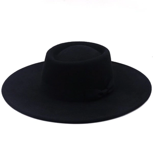 Détail d'un chapeau canotier classique en feutre noir avec bord plat et ruban assorti