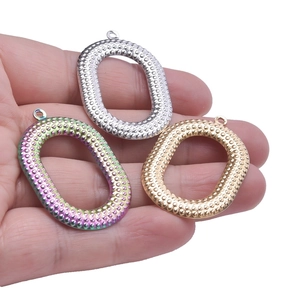 Three textured oval stainless steel pendants in silver, gold, and rainbow finishes