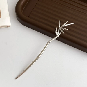 Detailed view of a silver bamboo-style hair pin with realistic leaf motif in metal