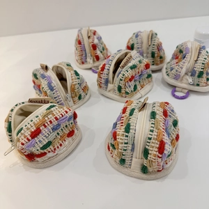 Detailed view of colorful hand-woven mini earphone cases with smooth zipper closures