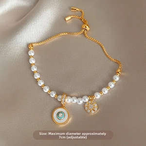 Détail du bracelet réglable en perles dorées avec pendentif bleu sur tissu en soie