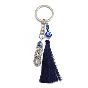 Blue evil eye keychain with silver feather pendant and tassel accessory for handbags