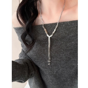 Detail of silver layered Y-shaped necklace with woven tassels and metallic beads