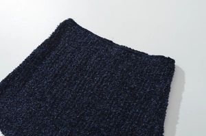Dettaglio ravvicinato del tessuto in maglia tweed blu scuro con texture intrecciata