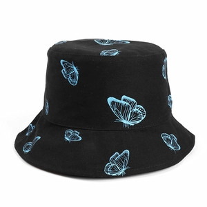 Détail d'un chapeau bob noir avec des motifs brodés de papillons bleus très contrastés