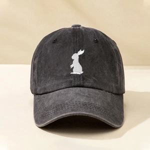 Close-up of a white rabbit embroidery on a dark grey washed denim baseball cap