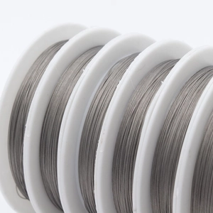 Macro shot of silver metal jewelry beading wire on white spools for DIY crafts