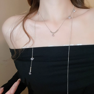 Détail du collier argenté multicouche avec perles en zircon porté par un mannequin chic