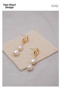 Detail view of French vintage double pearl earrings on white linen with gold metal knot clasps