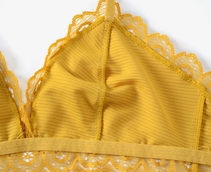 Macro detail of yellow lace lingerie showing ribbed mesh texture and floral embroidery