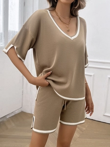 Detailed close-up of khaki V-neck knit set with sporty white contrast stripe trim