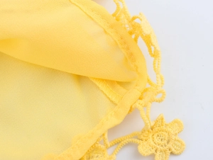 Close-up of yellow chiffon dress featuring delicate lace trim and 3D floral embroidery