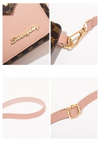 Detail of pink pebbled leather handbag with golden hardware and adjustable strap