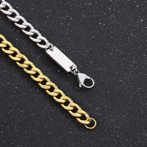 Close-up of gold and silver titanium steel NK chains with a rectangular metal tag