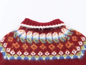 Detail of red Fair Isle knit cardigan featuring geometric patterns and a ribbed neckline