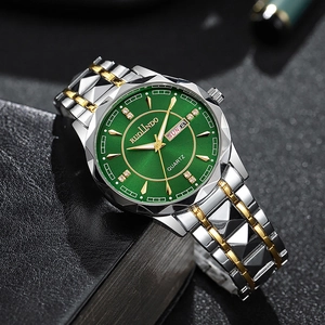 Macro detail of emerald green sunray dial with day-date window and gold-silver watch band