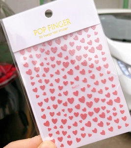 Close-up of pink heart 3D nail stickers model Me017 with glitter finish for manicure