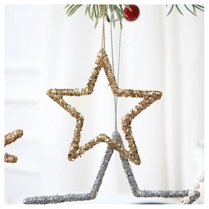 Detailed view of champagne gold sequined star ornament hanging on a festive Christmas tree