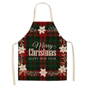 Close-up of Merry Christmas text and festive floral print on red plaid holiday apron