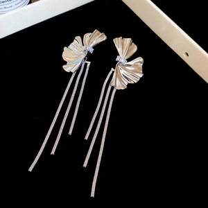 Detail of silver flower tassel earrings with zircons and sleek hanging snake chains