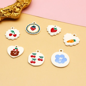 Detailed flat lay of cute enamel charms featuring rabbit, strawberry and cloud patterns