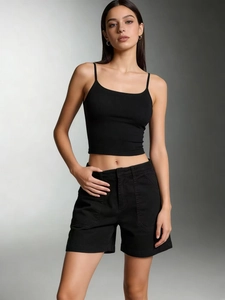 Dettaglio del top a canotta in maglia a coste nera slim-fit su modella in studio