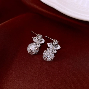Close-up of silver star pearl earrings with cubic zirconia on luxury red silk