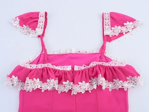 Dettaglio di abito rosa con bordi in pizzo a balze e decorazioni di paillettes argentate