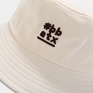 Minimalist beige twill cotton bucket hat with dark brown embroidered text decoration