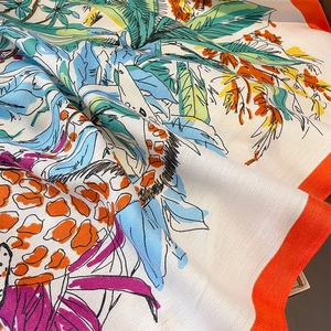 Detail of herringbone weave silk scarf with tropical jungle print and bright orange border