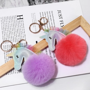 Detalle de llaveros de unicornio de peluche brillante con encaje y cierre dorado