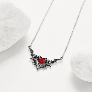 Gothic punk necklace with silver bat wings and a red heart gemstone on white stones