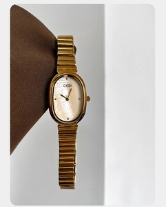 Detailed macro shot of an oval mother-of-pearl dial on a gold GEDI fashion watch