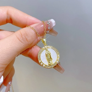 Macro detail of gold necklace with Virgin Mary relief, pearls, and sparkling crystals