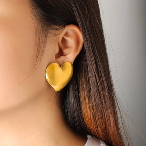 Close-up of model wearing oversized 18K gold-plated heart-shaped earrings for women