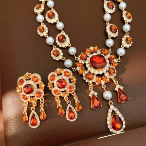Nahaufnahme von Vintage-Schmuckset mit orangen Edelsteinen, Perlen und Vergoldung