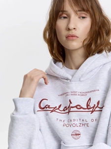 Dettaglio della felpa con cappuccio grigio chiaro oversize con stampa Saratov rossa e tasche