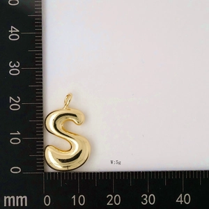 Detailed view of golden S-shaped bubble letter pendant weighing 5g with ruler measurement