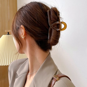 Large amber brown claw clip for thick hair shown in a minimalist bun hairstyle