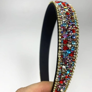 Close-up of luxury thin black headband with multicolored rhinestones in blue and red