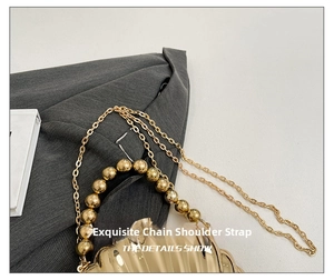 Detail of gold shell evening bag featuring a beaded handle and elegant metal chain strap